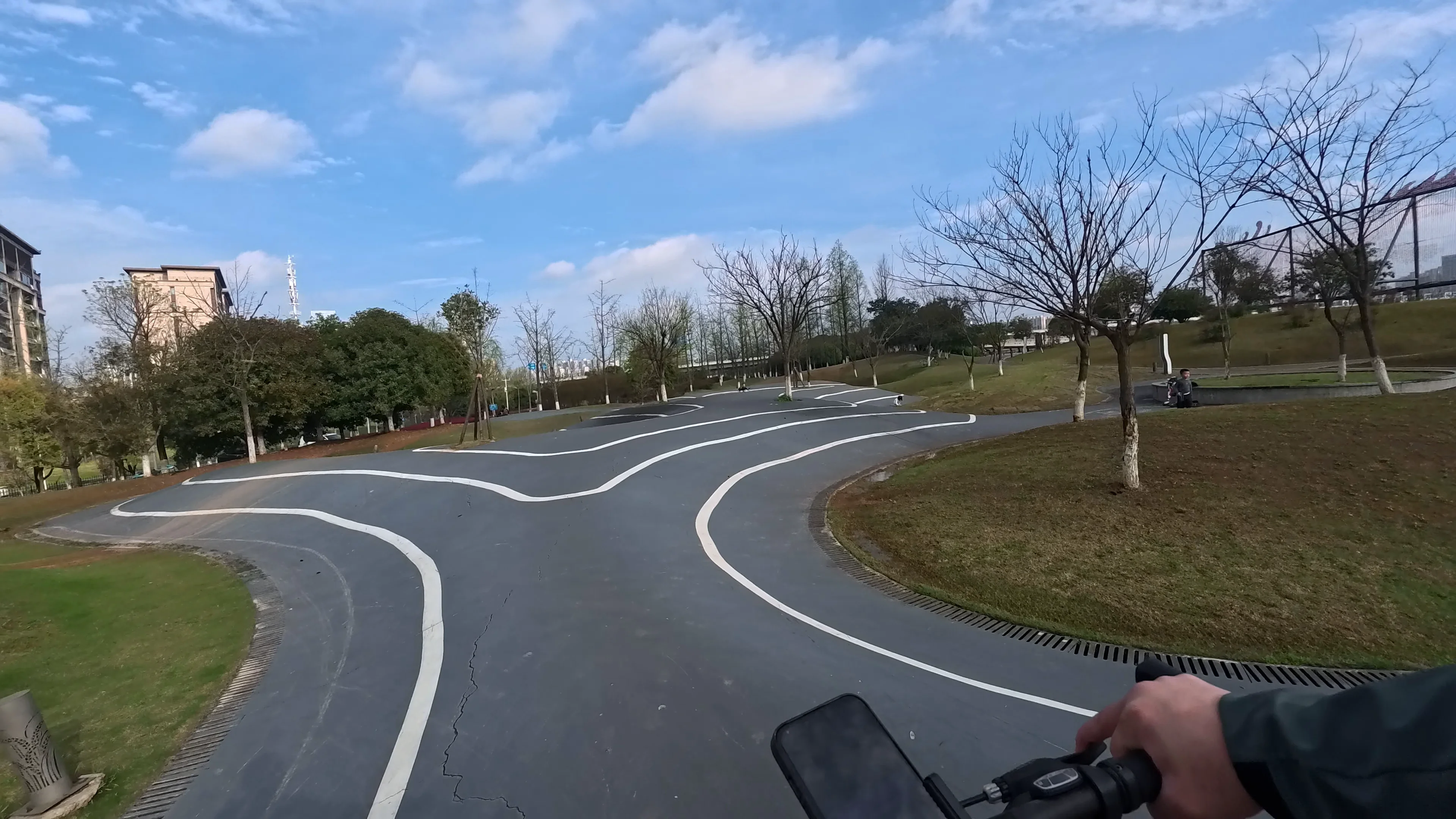POV cycling through a flowing modern bike lane inside a peaceful urban park in Changsha, China under a bright blue sky