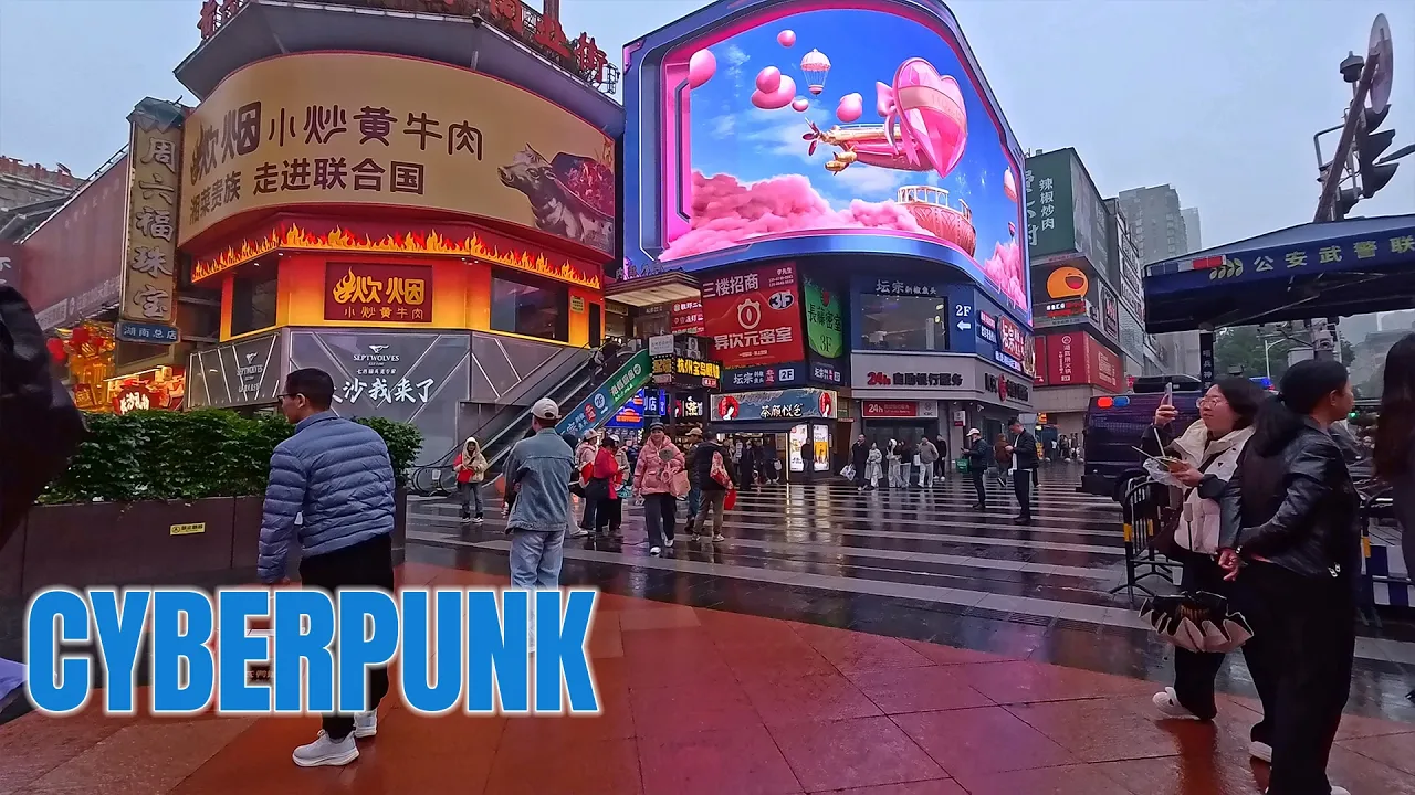 Neon reflections on rain-soaked streets beneath glowing LED billboards